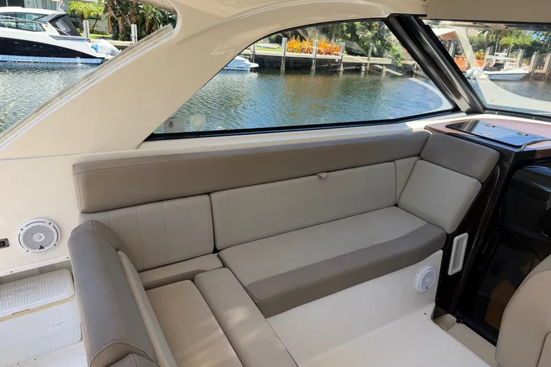 Slide: The Image of Interior of a 2015 Regal 35 Sport Coupe boat with beige seating and waterfront view. - 13