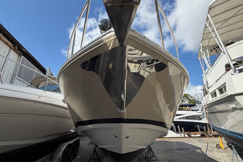 Slide: The Image of 2015 Regal 35 Sport Coupe boat in storage, viewed from the front under a clear blue sky. - 9