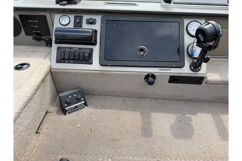Slide: The Image of 2001 Lund 1775 Pro-V boat dashboard with controls and foot trim pedal. - 9