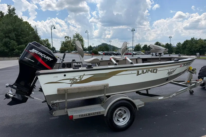 Slide: The Image of 2001 Lund 1775 Pro-V boat on trailer with Mercury engine, parked outdoors. - 5