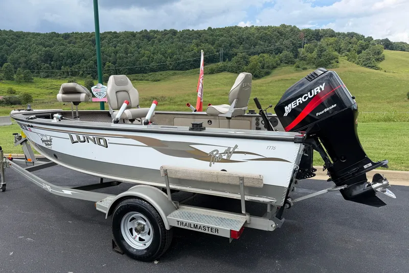 Slide: The Image of 2001 Lund 1775 Pro-V boat with Mercury engine on a trailer, parked outdoors. - 4