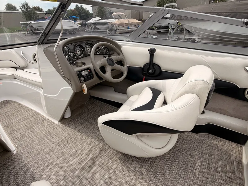 Slide: The Image of The image shows the cockpit of a 2009 Crownline 185 SS boat with a sleek steering wheel and comfortable seating. - 29