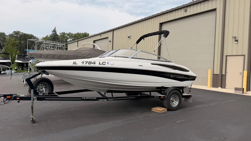 The Image of A 2009 Crownline 185 SS boat on a trailer in front of a warehouse building. - 0