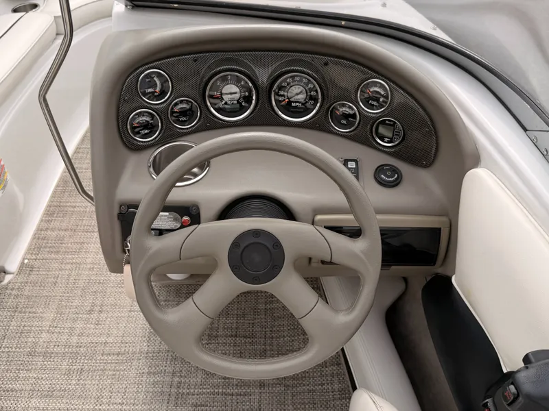 Slide: The Image of The image shows the dashboard of a 2009 Crownline 185 SS boat with multiple gauges and a steering wheel. - 32