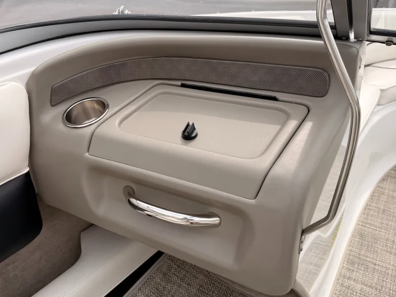 Slide: The Image of The image shows the dashboard of a 2009 Crownline 185 SS boat with a cup holder and storage compartment. - 28
