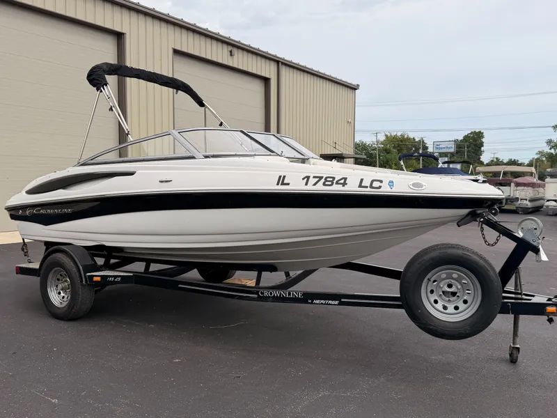 Slide: The Image of A 2009 Crownline 185 SS boat on a trailer parked in front of a building. - 5