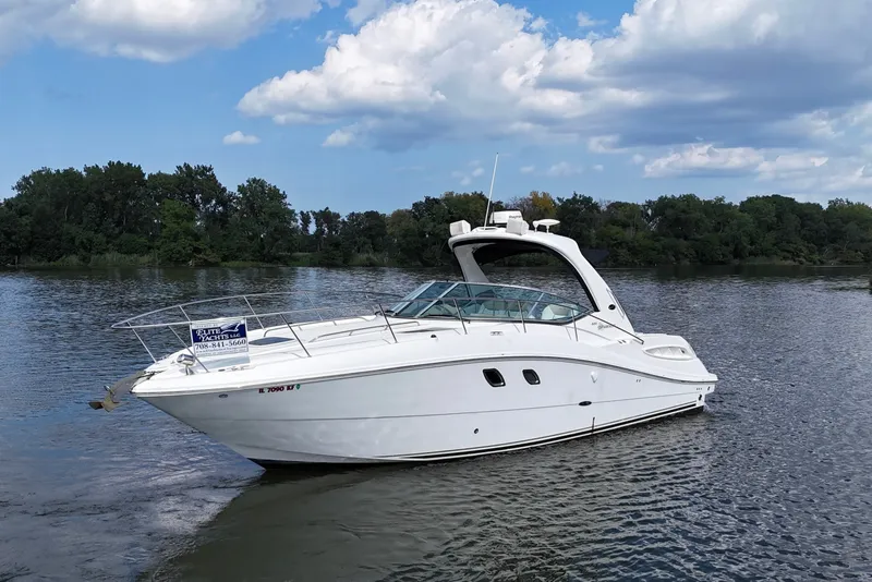 The Image of 2008 Sea Ray Sundancer 330 yacht on a serene lake with trees in the background. - 0