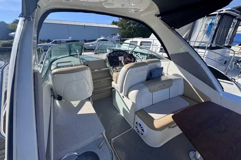 Slide: The Image of 2008 Sea Ray 350 Sundancer cockpit with seating, helm, and table, docked at marina. - 10