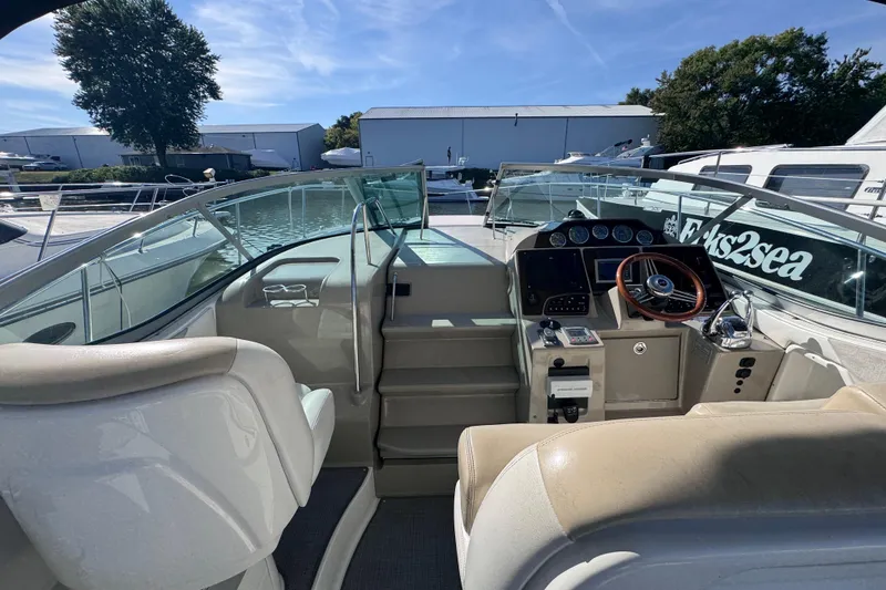 Slide: The Image of 2008 Sea Ray 350 Sundancer cockpit with steering wheel and control panel, docked under clear sky. - 17