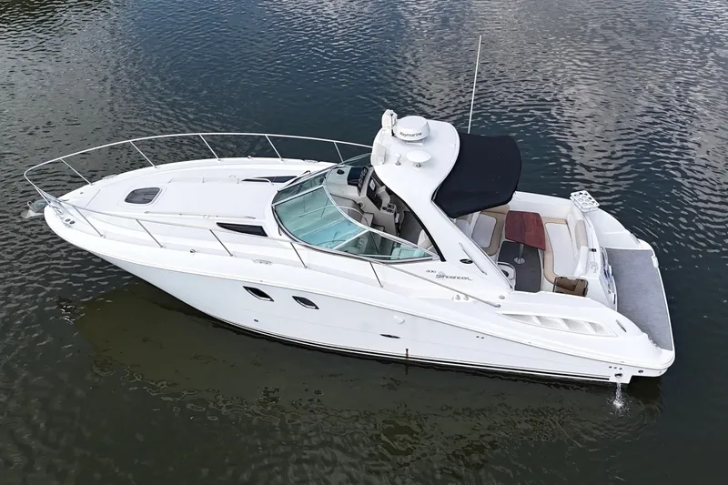 Slide: The Image of 2008 Sea Ray Sundancer 330 yacht on calm water, featuring sleek design and spacious deck. - 2