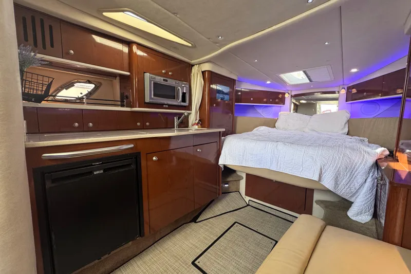 Slide: The Image of Luxurious interior of 2008 Sea Ray 350 Sundancer yacht with bed, kitchenette, and ambient lighting. - 30