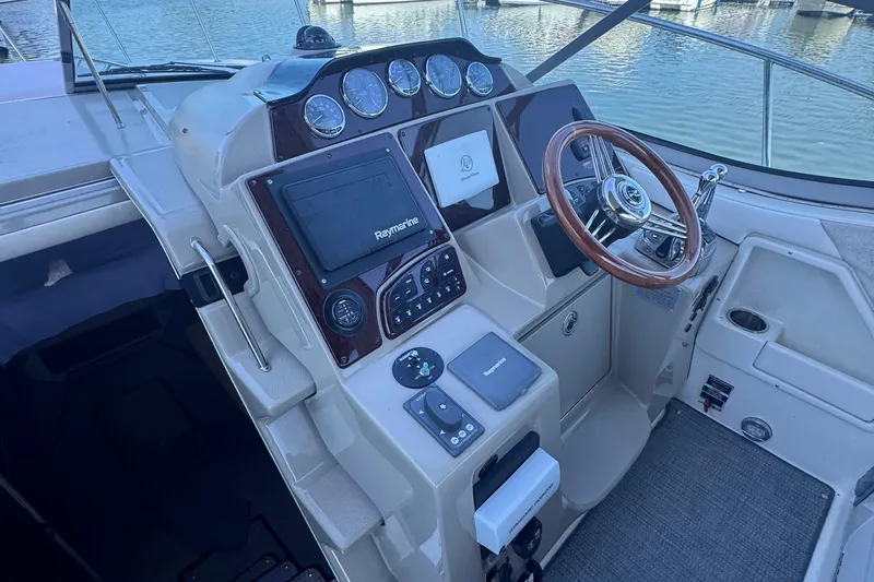 Slide: The Image of 2008 Sea Ray 350 Sundancer helm with Raymarine electronics and wooden steering wheel. - 19