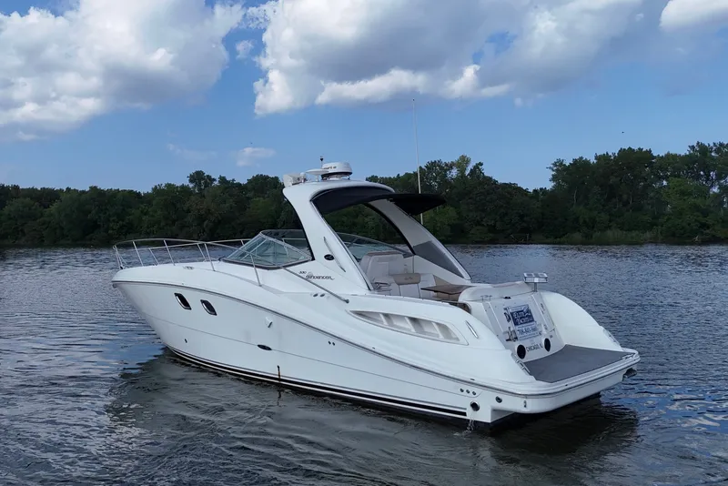 Slide: The Image of 2008 Sea Ray Sundancer 330 yacht on a serene lake with lush green shoreline. - 1