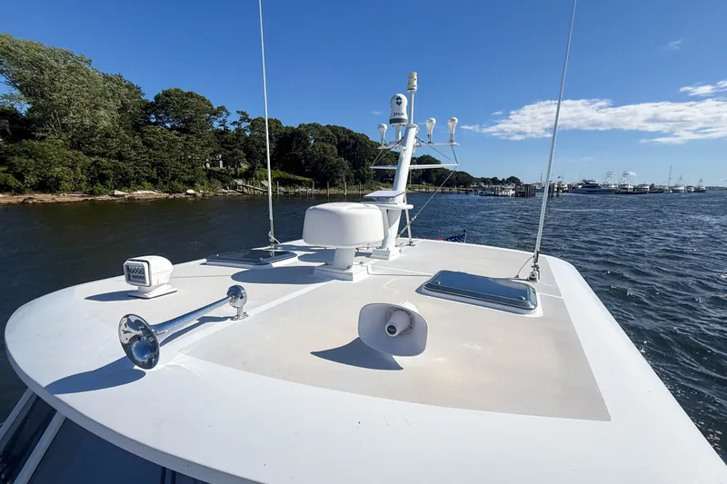 Slide: The Image of 2003 Grand Banks 38 Eastbay HX yacht cruising on a sunny day near a wooded shoreline. - 43