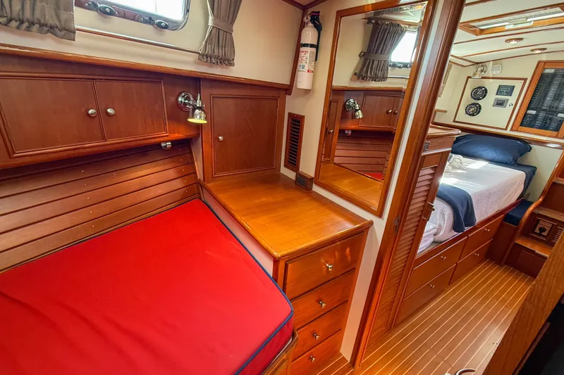 Slide: The Image of Luxurious 2003 Grand Banks 38 Eastbay HX cabin interior with wood finish and cozy bedding. - 30