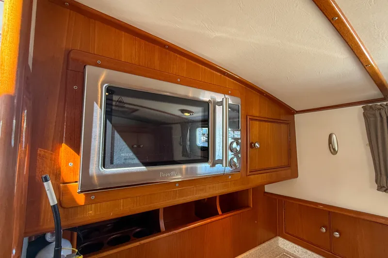 Slide: The Image of 2003 Grand Banks 38 Eastbay HX interior with microwave and wooden cabinetry. - 20