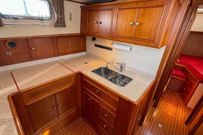 Slide: The Image of Luxurious 2003 Grand Banks 38 Eastbay HX yacht kitchen with wood cabinetry and dual sink. - 23