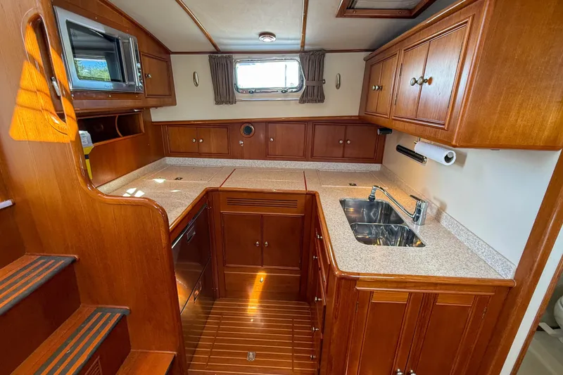 Slide: The Image of 2003 Grand Banks 38 Eastbay HX yacht kitchen with wood cabinetry and modern appliances. - 18