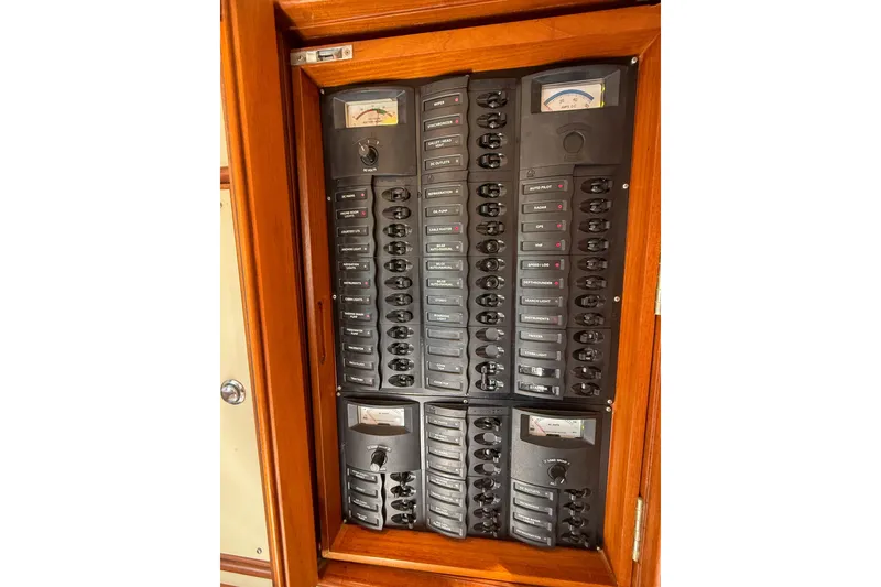 Slide: The Image of Electrical panel on a 2003 Grand Banks 38 Eastbay HX yacht, featuring multiple switches and gauges. - 46