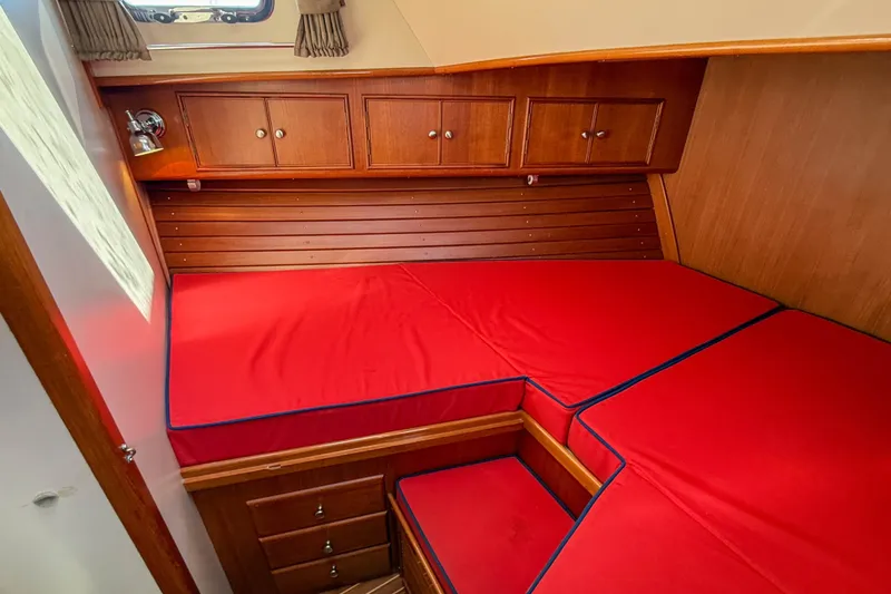 Slide: The Image of 2003 Grand Banks 38 Eastbay HX cabin with red cushions and wooden cabinetry. - 28