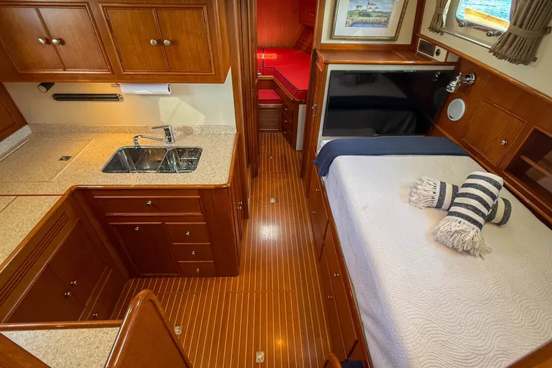 Slide: The Image of Luxurious 2003 Grand Banks 38 Eastbay HX yacht interior with wood cabinetry and cozy sleeping area. - 17