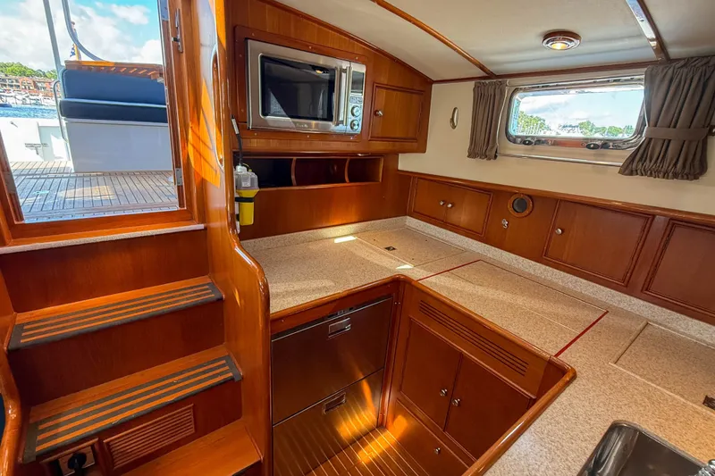 Slide: The Image of Interior of 2003 Grand Banks 38 Eastbay HX yacht, featuring wooden cabinetry and modern appliances. - 19