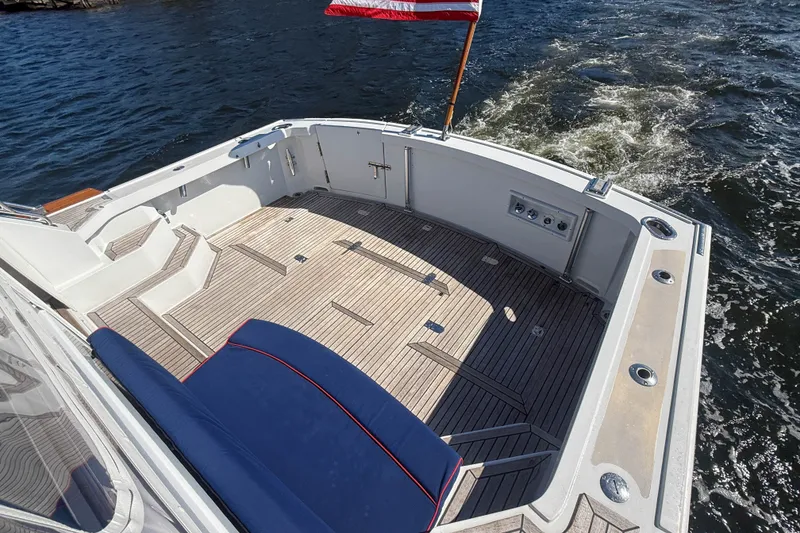 Slide: The Image of 2003 Grand Banks 38 Eastbay HX yacht deck with American flag, cruising on water. - 36