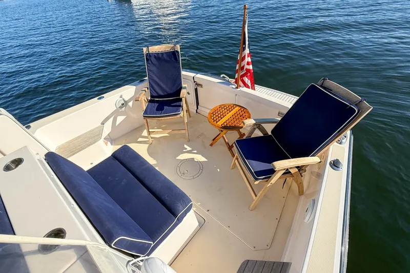 Slide: The Image of Cozy seating area on 2008 True North 34 boat with American flag, overlooking water. - 23