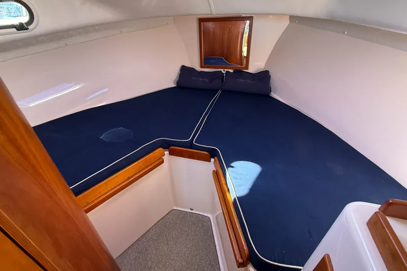 Slide: The Image of 2008 True North 34 boat cabin with blue bedding and wooden accents. - 28