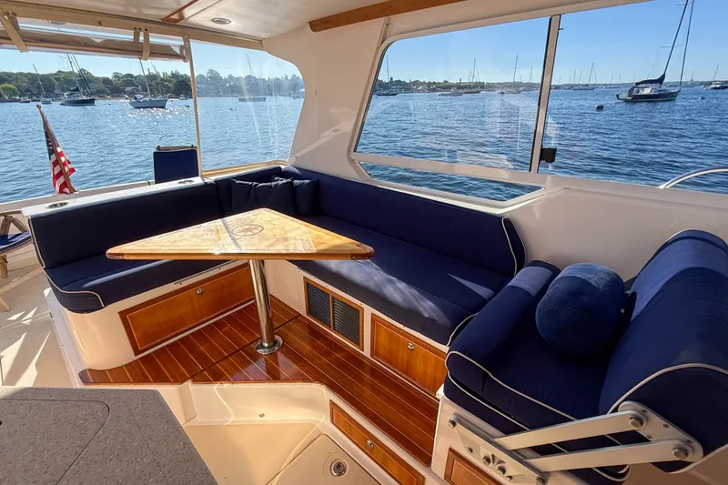 Slide: The Image of Luxurious 2008 True North 34 yacht interior with blue seating and wooden table, overlooking serene waters. - 9