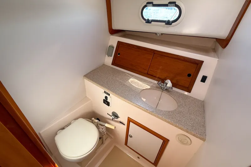 Slide: The Image of Compact boat bathroom with sink, toilet, and storage in a 2008 True North 34 model. - 29