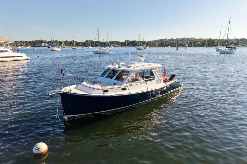 Slide: The Image of 2008 True North 34 boat on a calm lake with sailboats in the background. - 1