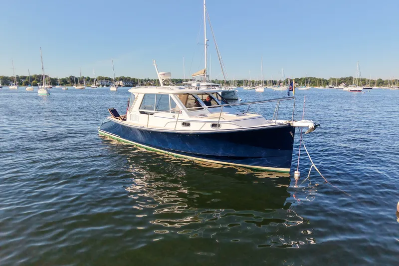 Slide: The Image of 2008 True North 34 boat anchored in a scenic harbor with sailboats. - 2