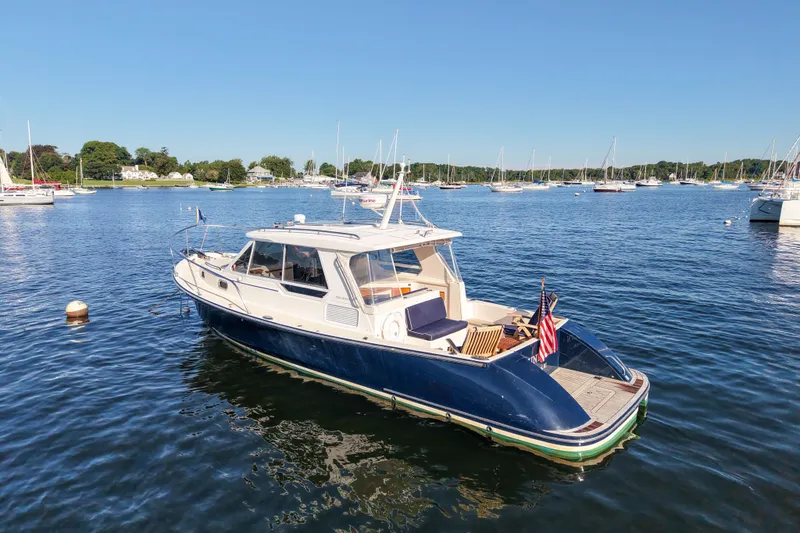 Slide: The Image of 2008 True North 34 yacht on calm water, surrounded by sailboats under clear blue sky. - 3