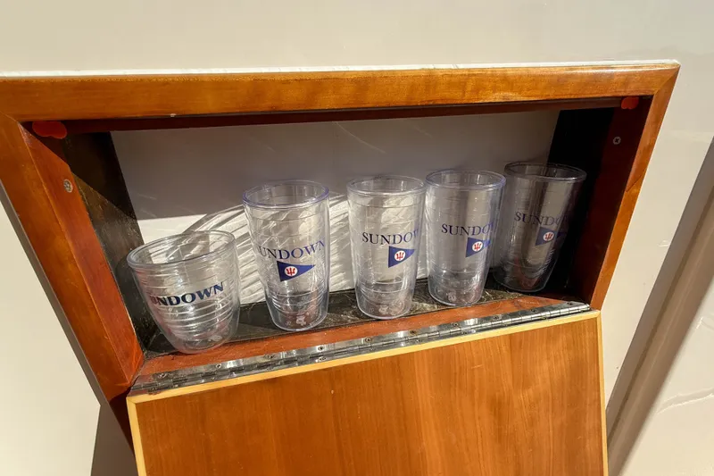 Slide: The Image of Clear plastic cups labeled "Sundown" in a wooden shelf on a 2008 True North 34. - 17