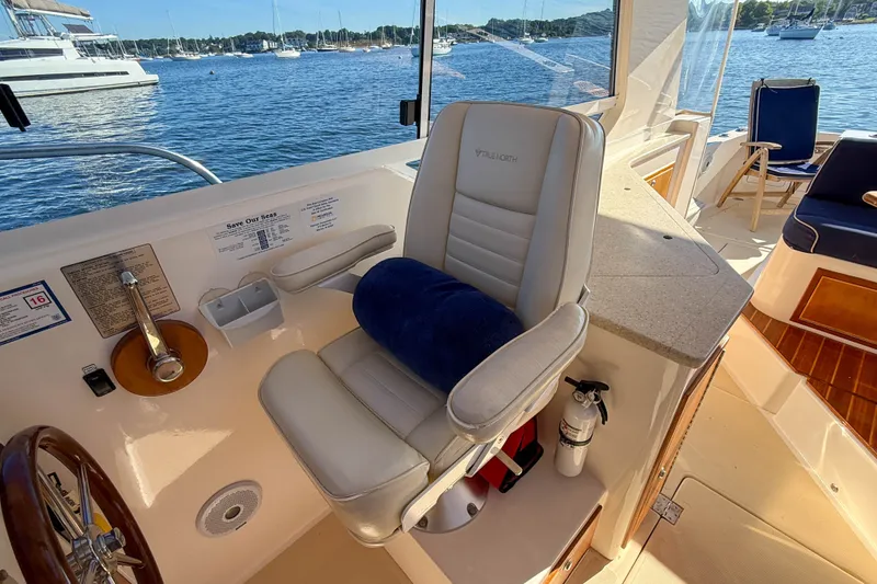 Slide: The Image of Captain's chair on 2008 True North 34 boat, overlooking serene marina waters. - 14