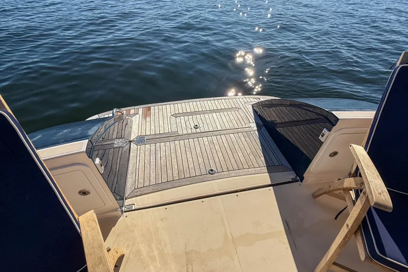 Slide: The Image of 2008 True North 34 boat deck with wooden chairs overlooking calm water. - 36