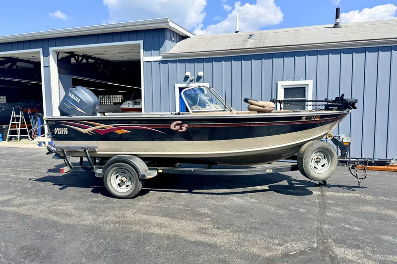 The Image of 2008 G3 Angler V185 FS boat on trailer, parked outside a blue building. - 5