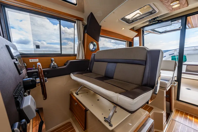 Slide: The Image of Interior of 2016 Ranger Tug 29 boat with seating and helm, showcasing modern design. - 16