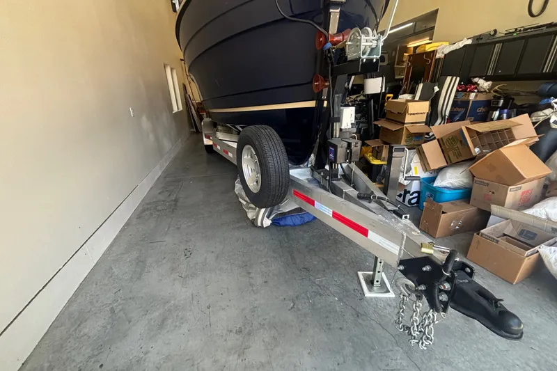 Slide: The Image of 2015 Ranger Tugs R-25 SC boat on trailer in garage with storage boxes. - 39