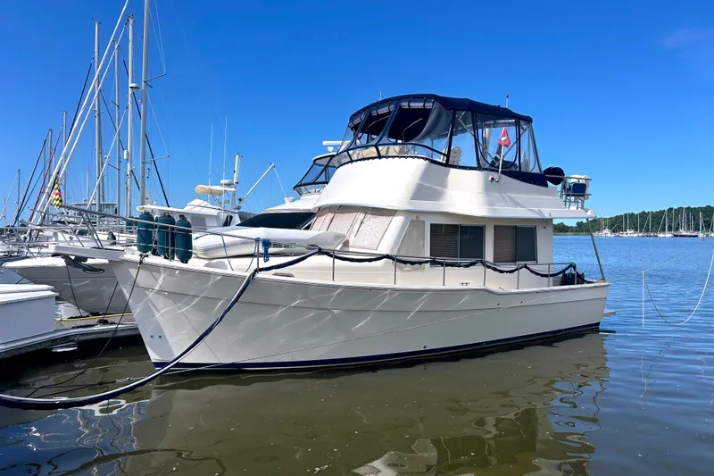 The Image of 2008 Mainship 34 Trawler docked at marina under clear blue sky. - 0