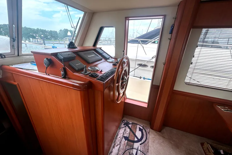 Slide: The Image of Interior helm of 2008 Mainship 34 Trawler with wooden steering wheel and navigation equipment. - 13