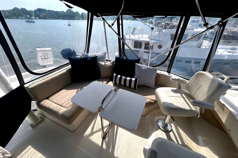 Slide: The Image of Interior of 2008 Mainship 34 Trawler with seating and table, overlooking marina. - 35