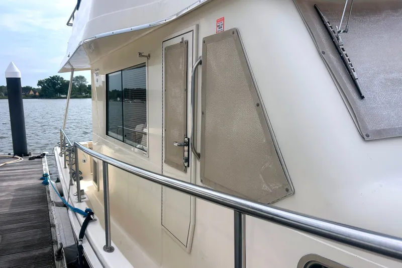 Slide: The Image of 2008 Mainship 34 Trawler docked, showcasing side view and railing details. - 27