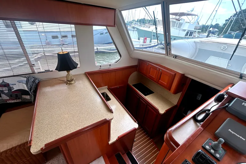 Slide: The Image of 2008 Mainship 34 Trawler interior with wood cabinetry, countertop, and nautical decor. - 12
