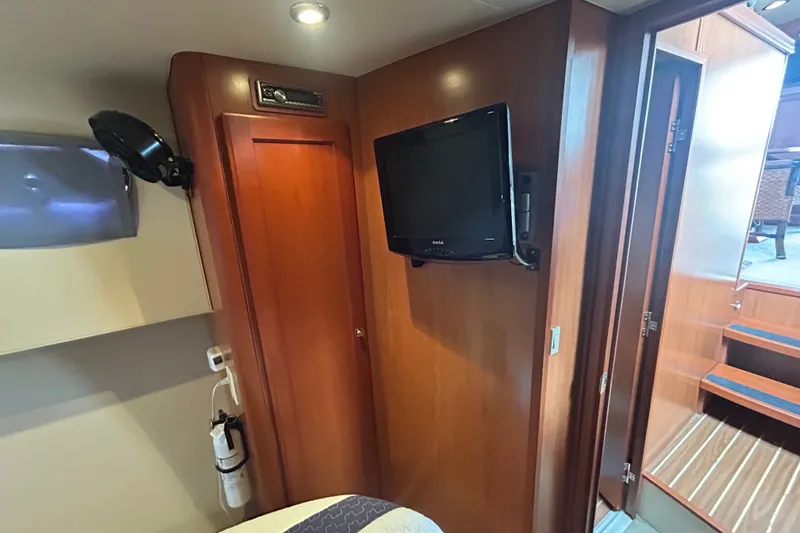 Slide: The Image of Interior of 2008 Mainship 34 Trawler with TV, wooden cabinetry, and stairs. - 24