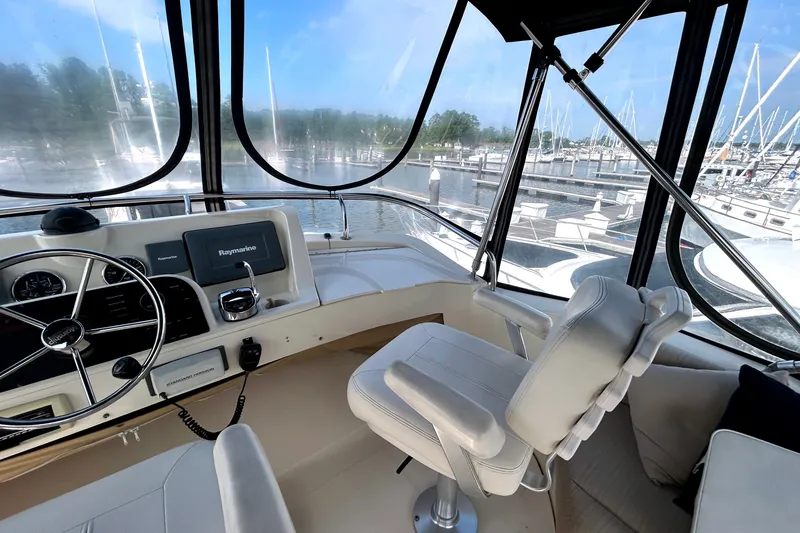 Slide: The Image of 2008 Mainship 34 Trawler helm with Raymarine electronics, marina view in background. - 33