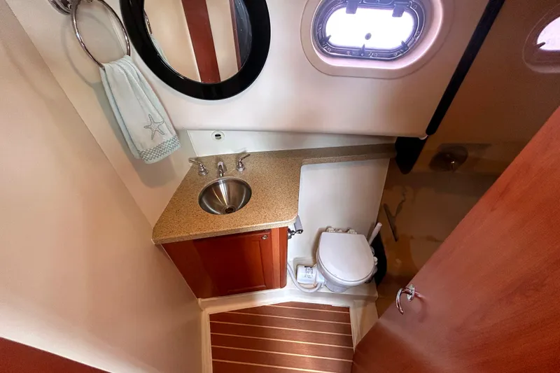 Slide: The Image of Bathroom interior of 2008 Mainship 34 Trawler with sink, toilet, and porthole window. - 19