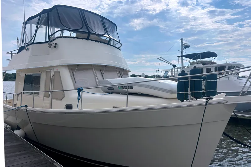 Slide: The Image of 2008 Mainship 34 Trawler docked at marina under a partly cloudy sky. - 4