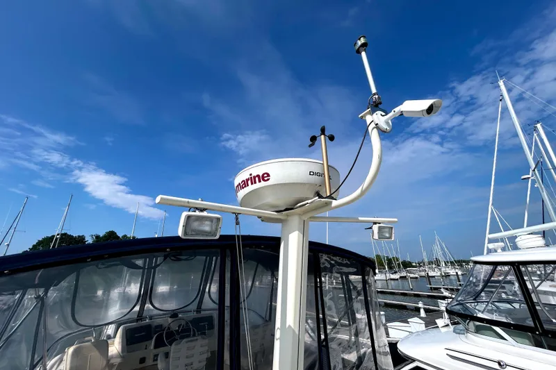Slide: The Image of Radar and navigation equipment on a 2008 Mainship 34 Trawler under a clear blue sky. - 37